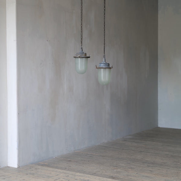 A pair of large industrial pendant lights