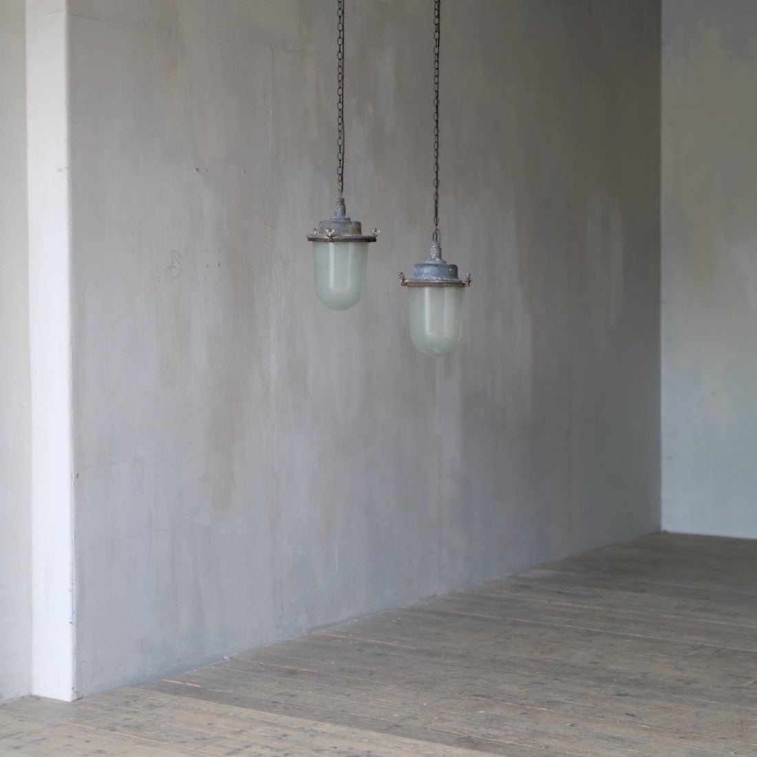 A pair of large industrial pendant lights