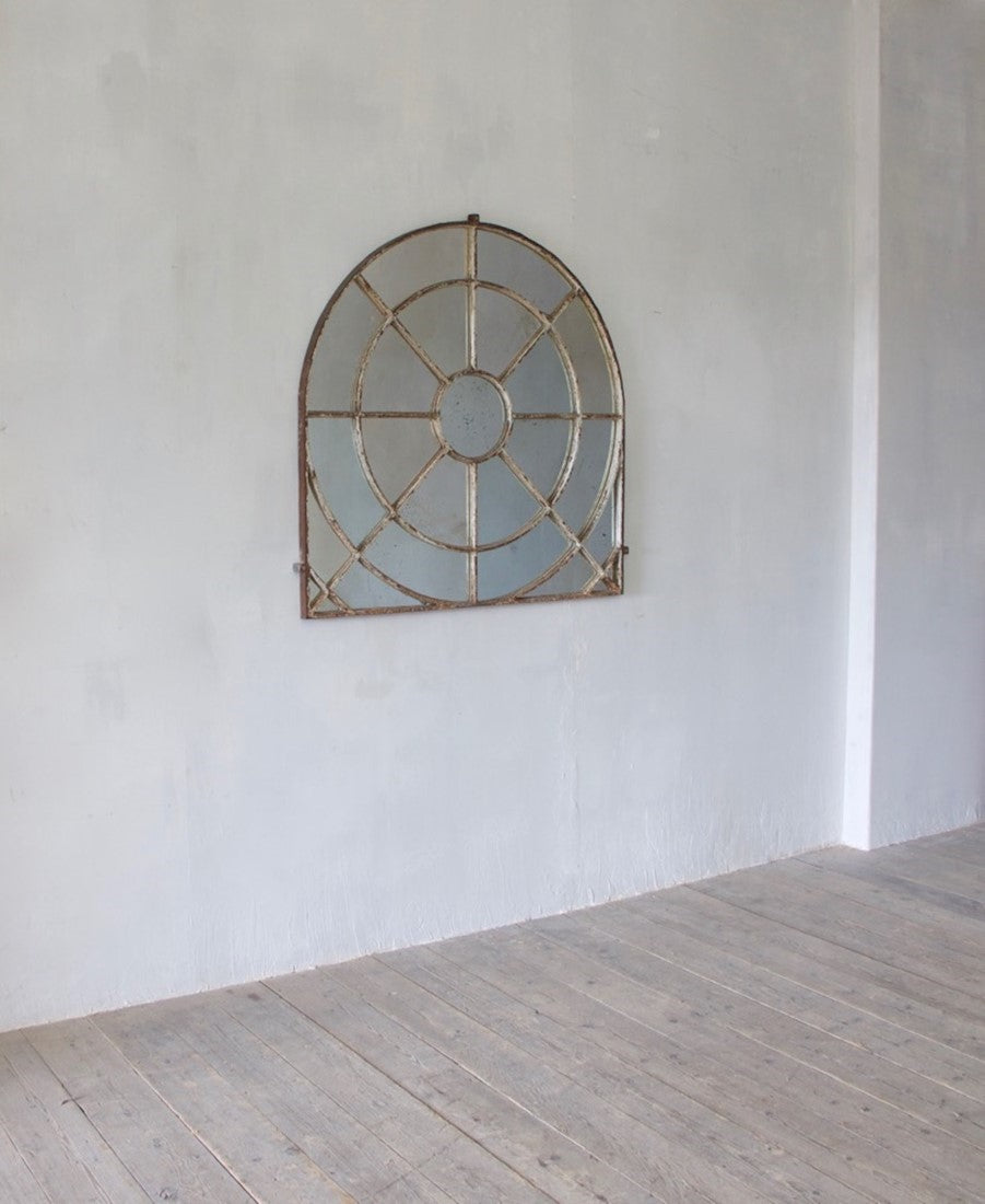 An unusual overmantle shaped cast iron window mirror