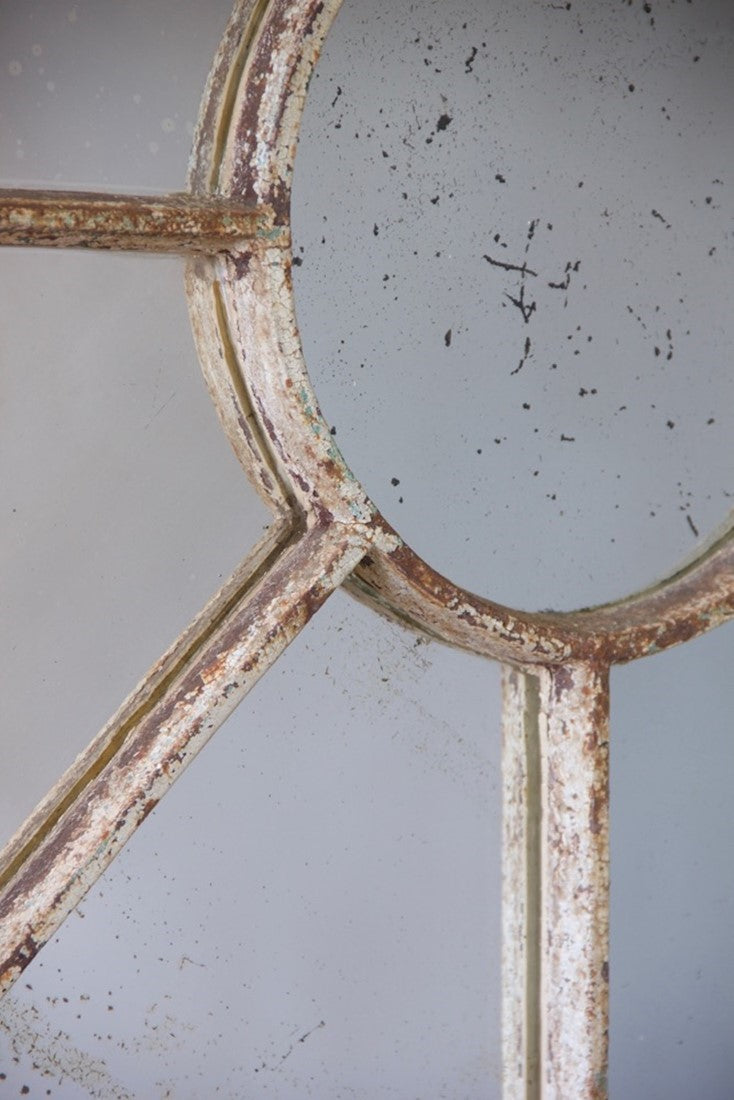 An unusual overmantle shaped cast iron window mirror
