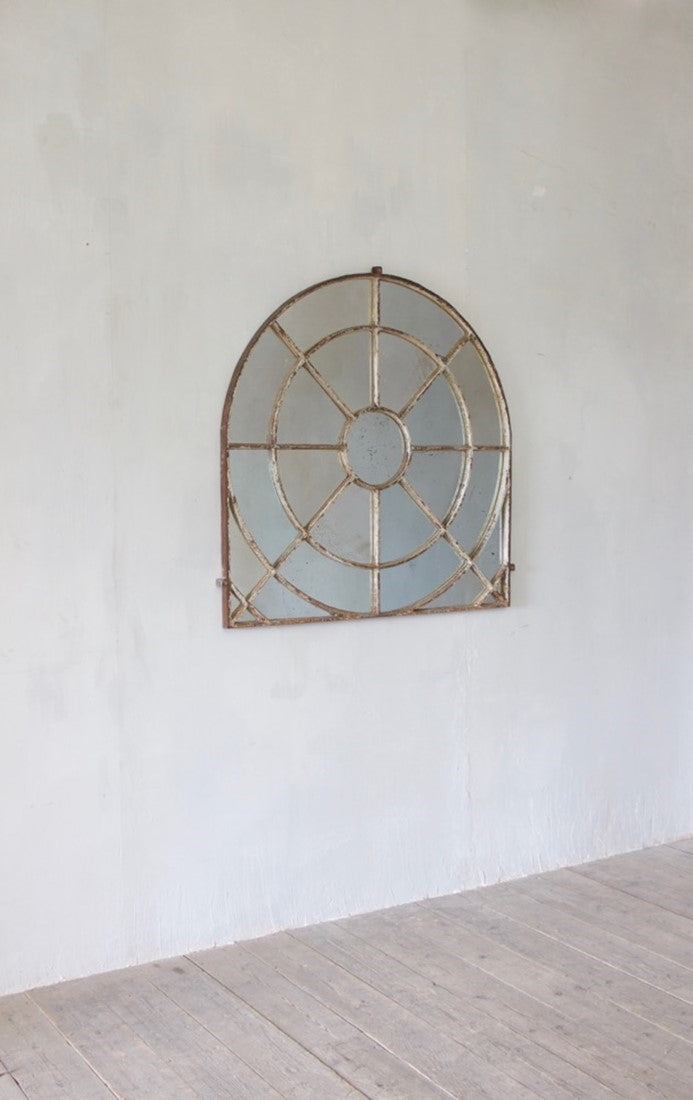 An unusual overmantle shaped cast iron window mirror