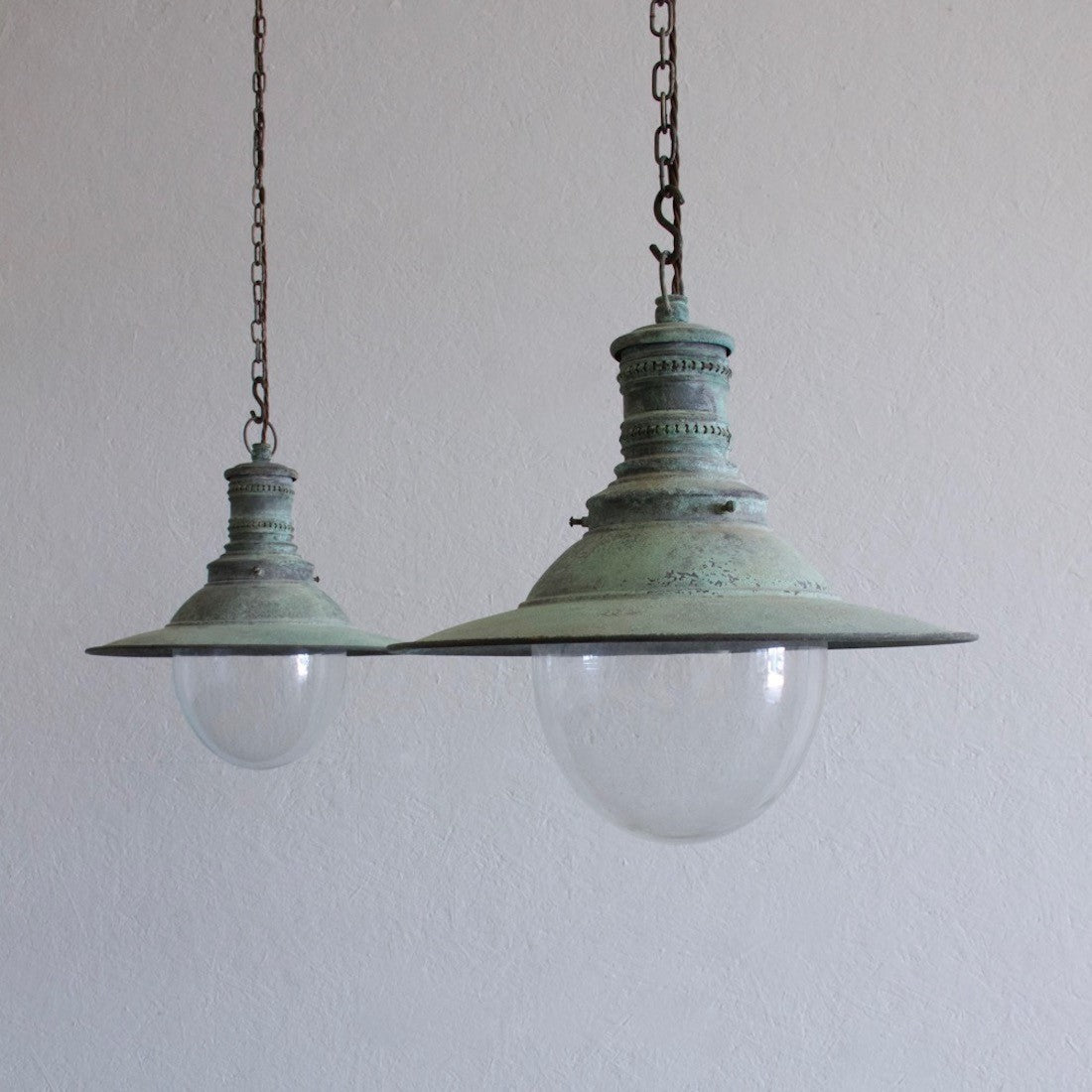 A pair of verdigris copper pendant lights