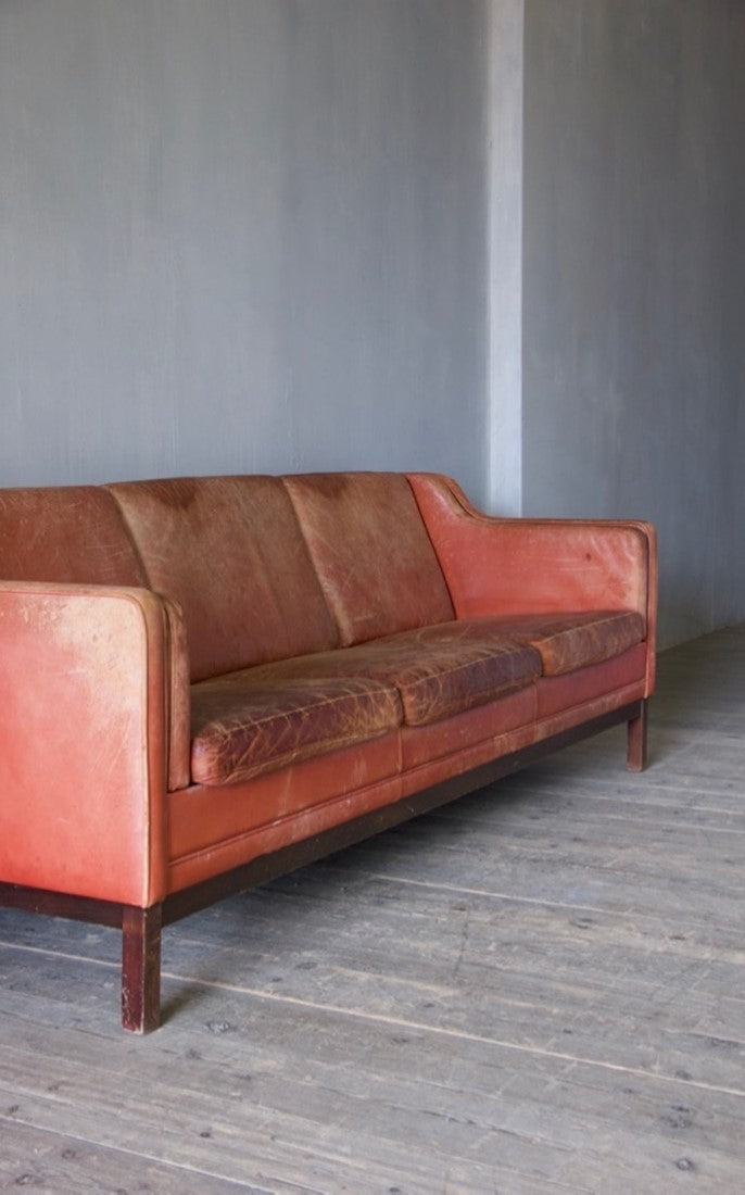 A large mid-century red leather sofa
