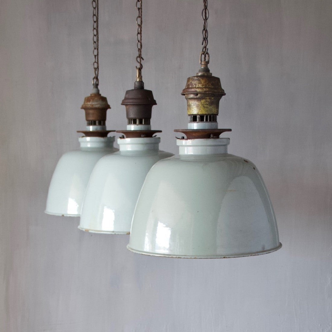 A set of three large enamelled pendant lights