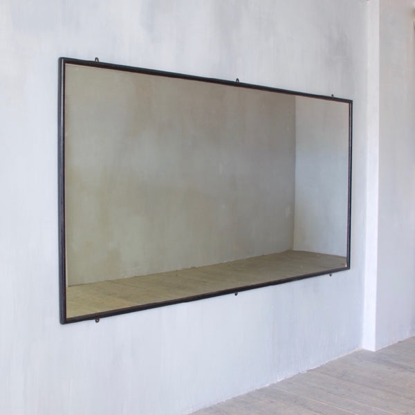 A very large ebonised shop mirror
