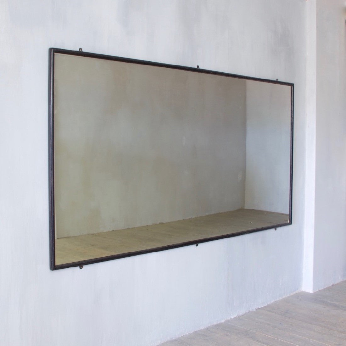 A very large ebonised shop mirror