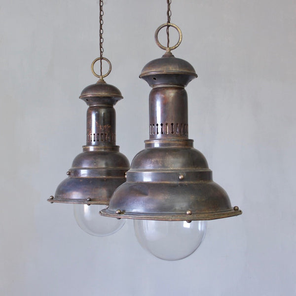 A pair of large brass pendants