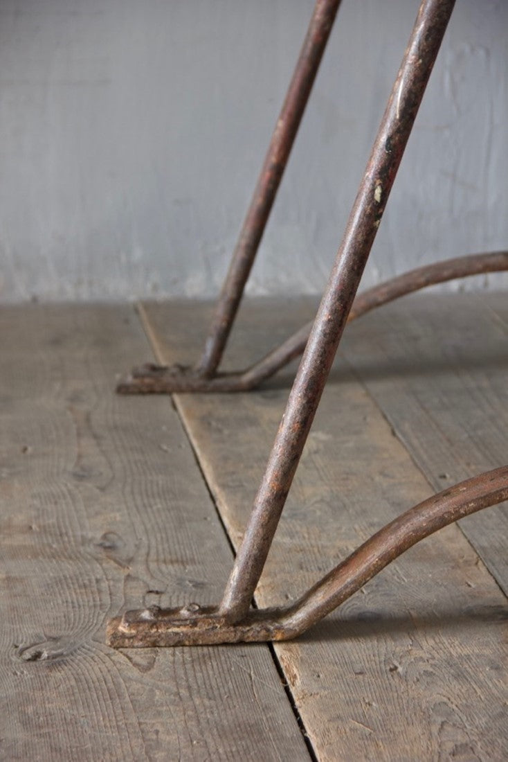 An architectural wrought iron trestle table