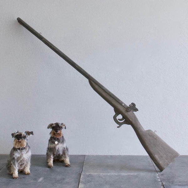 An oversized wooden model of a gun
