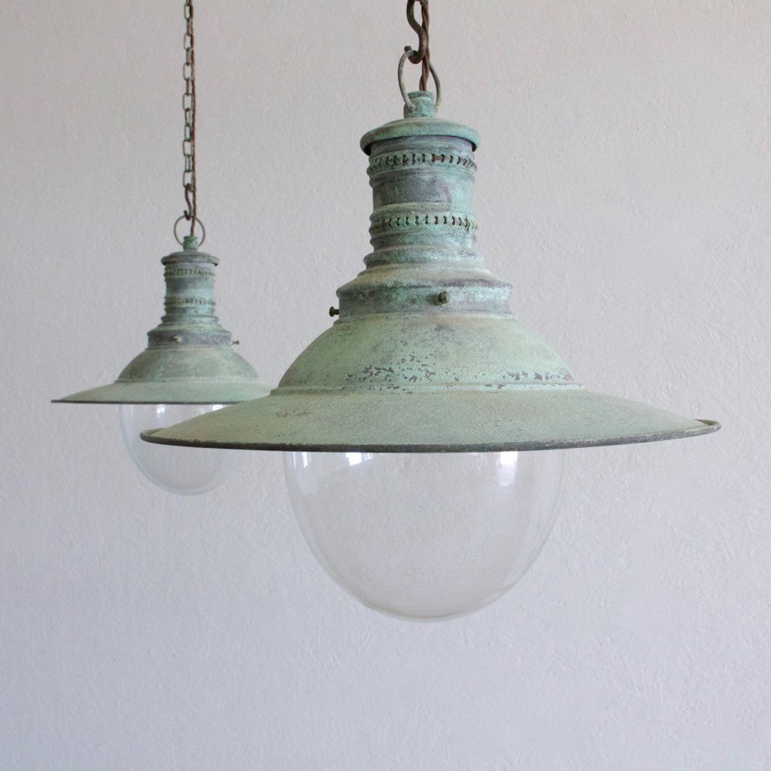 A pair of verdigris copper pendant lights