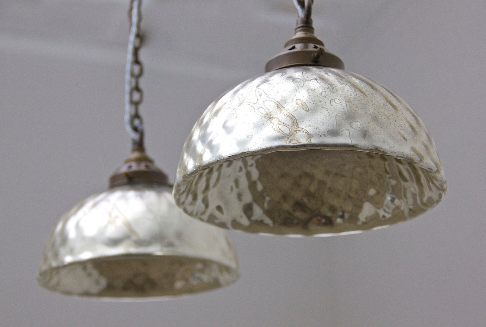 A pair of mercury glass pendant lights