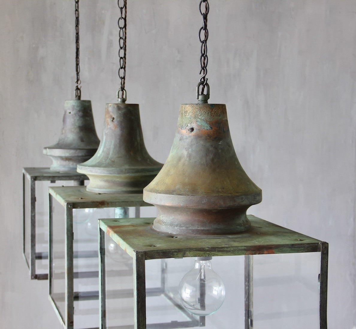A set of three verdigris copper lanterns