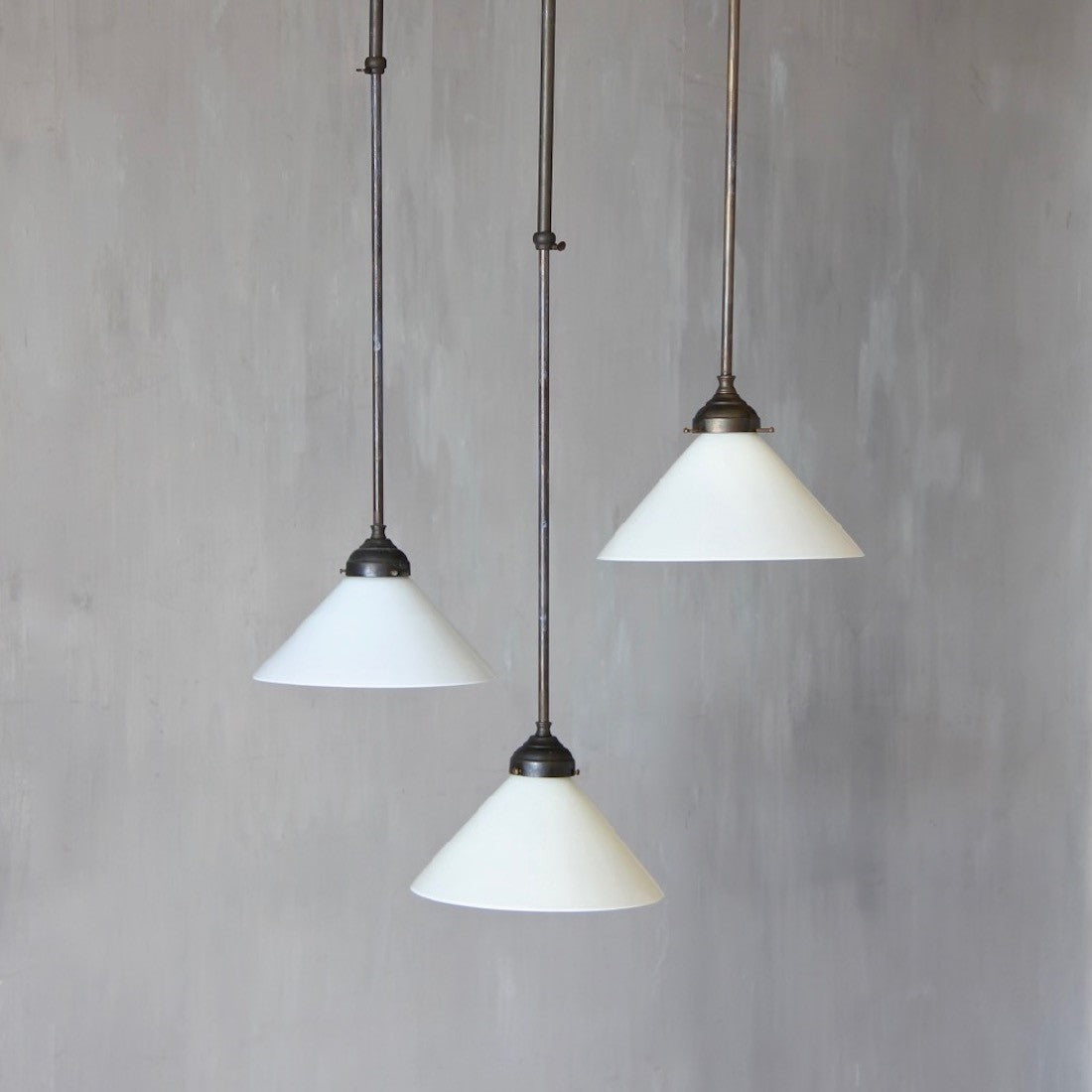 A set of 3 adjustable milk glass pendant lights