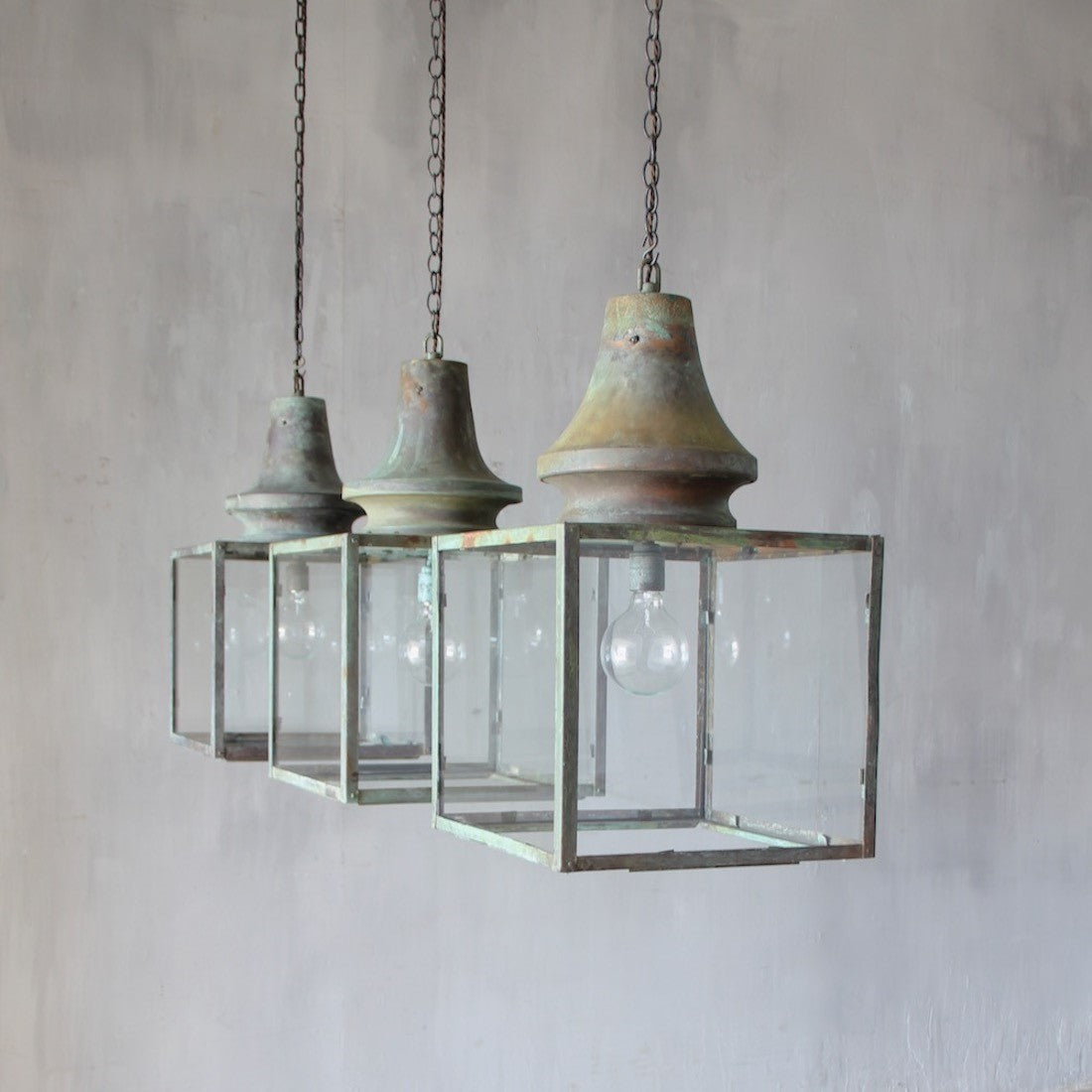 A set of three verdigris copper lanterns