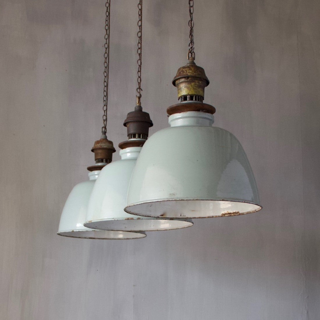 A set of three large enamelled pendant lights