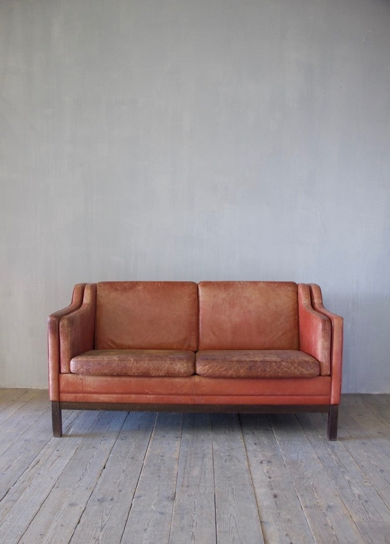 A mid-century red leather sofa