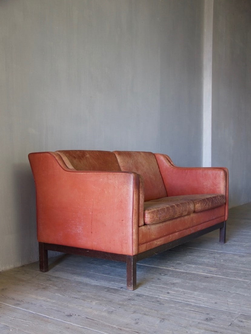 A mid-century red leather sofa