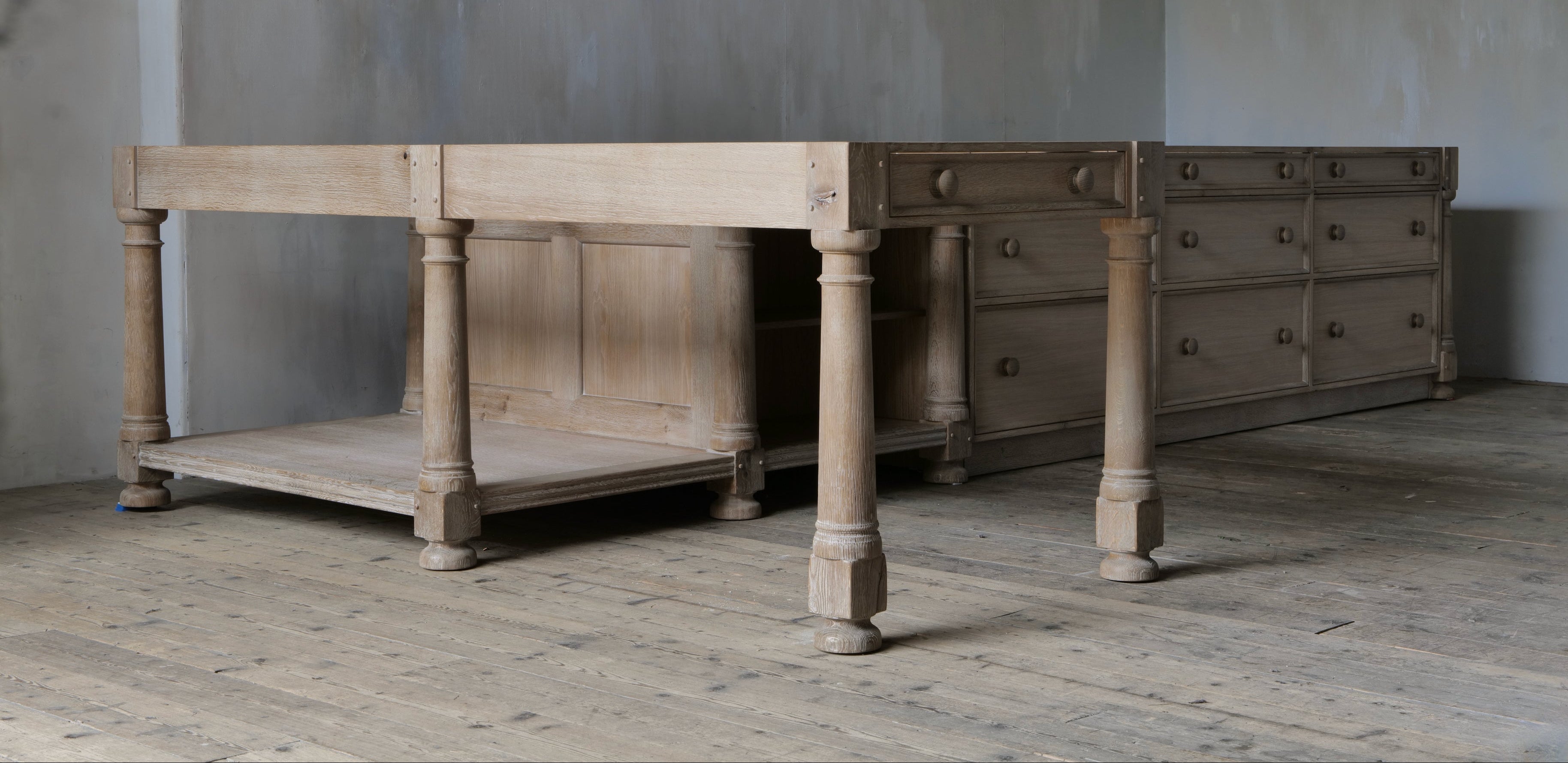 Large wooden table and dresser against a gray wall.