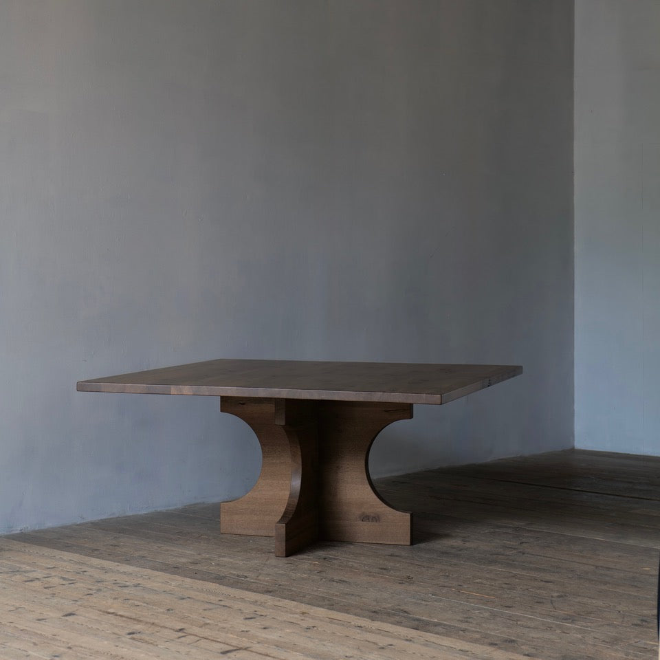 Wooden dining table against a gray wall