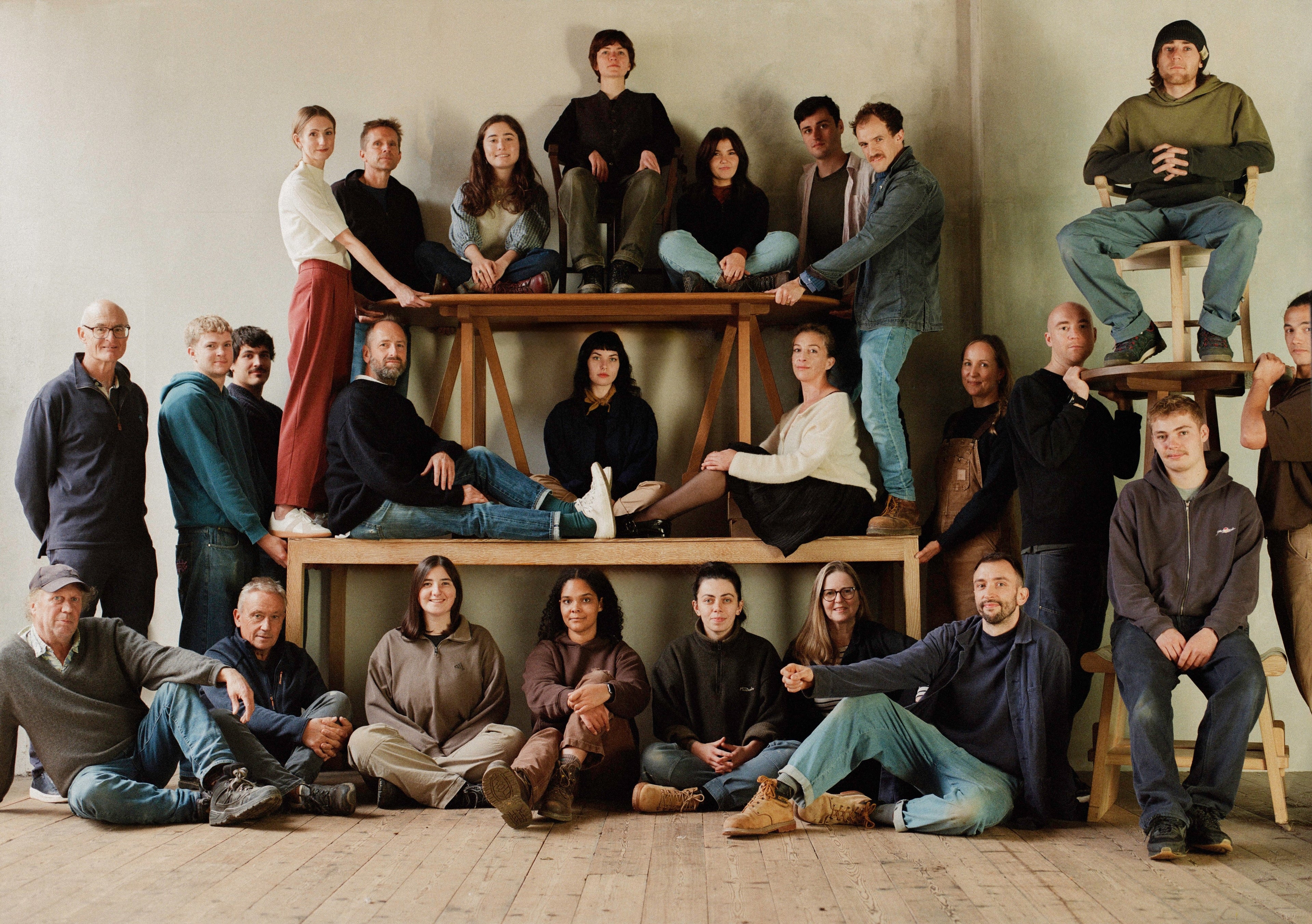 Matthew Cox team posing together in a casual setting with wooden benches.