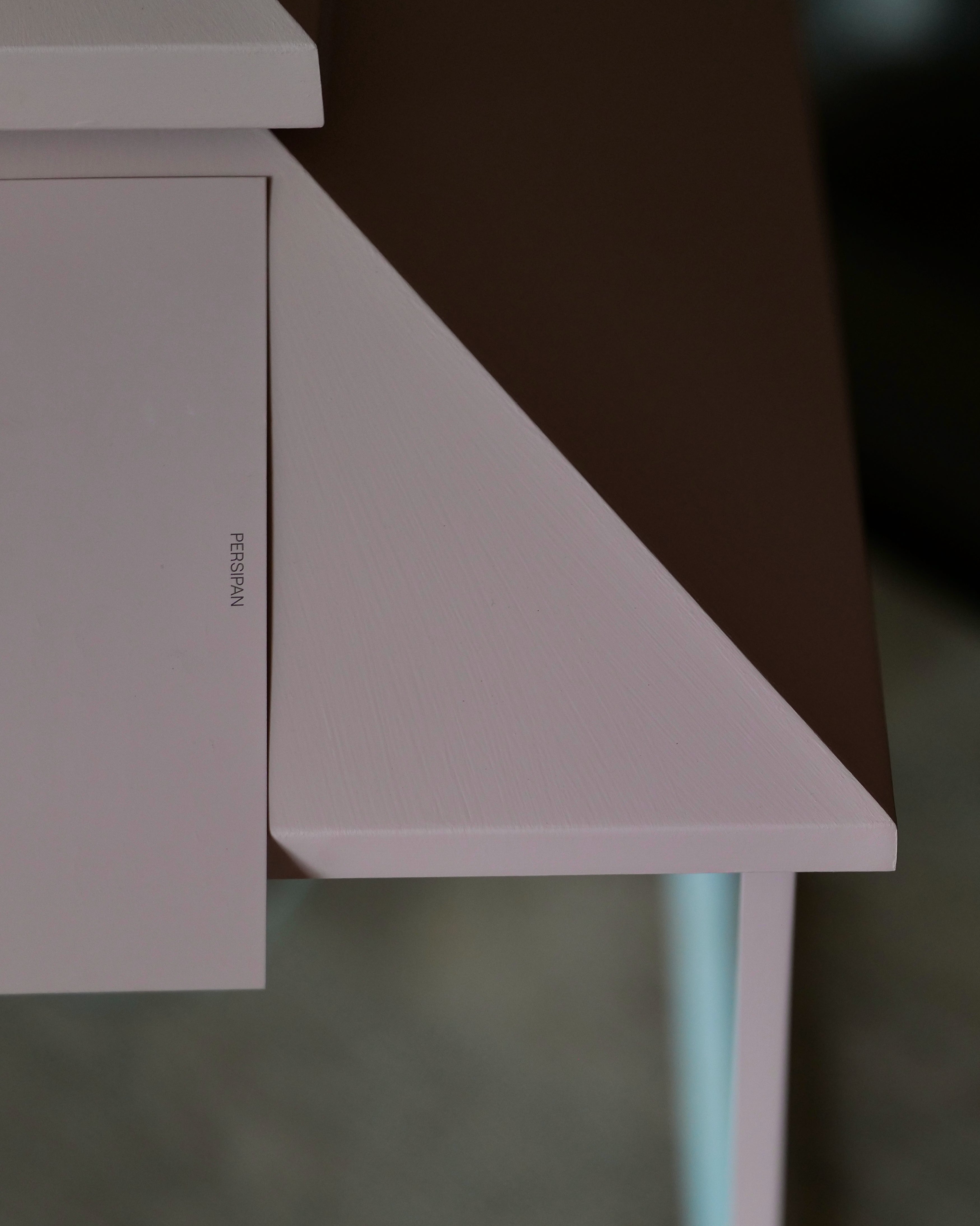 A close-up of the roof of a pale pink painted lantern against a paint swatch with the colour name 'PERSIPAN' printed on it.