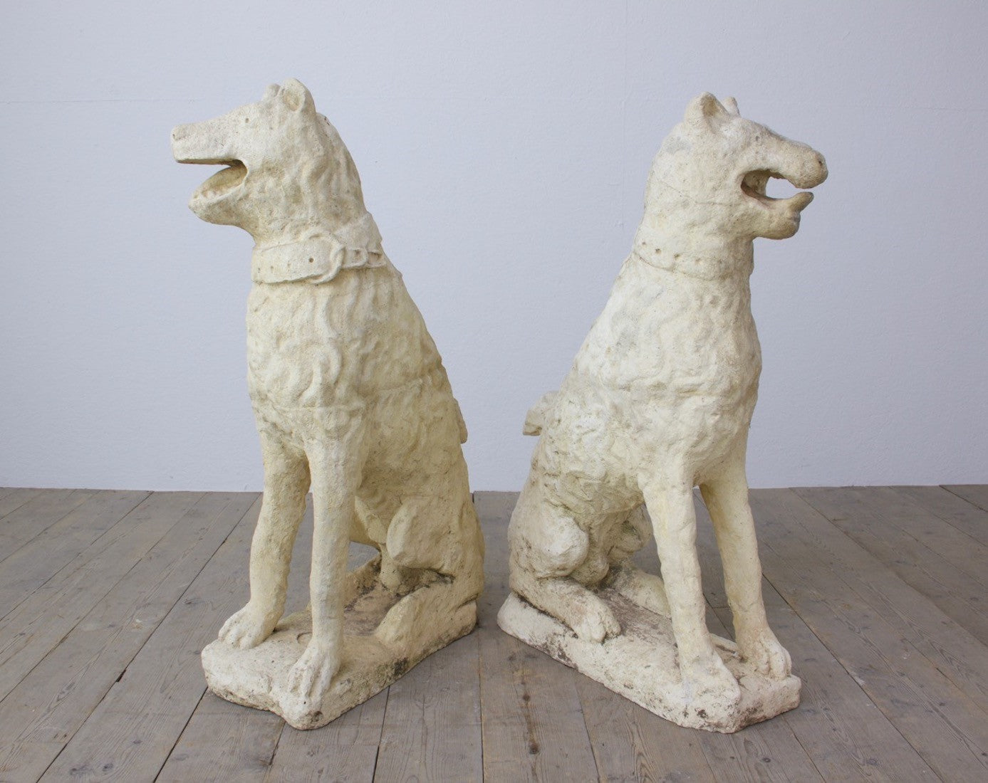 A pair of cast stone dogs