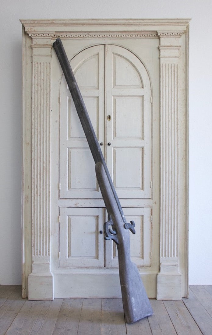 An oversized wooden model of a gun