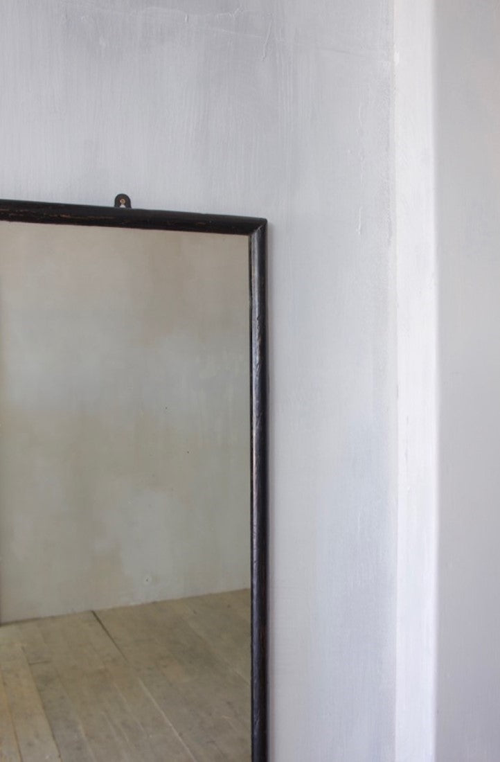 A very large ebonised shop mirror