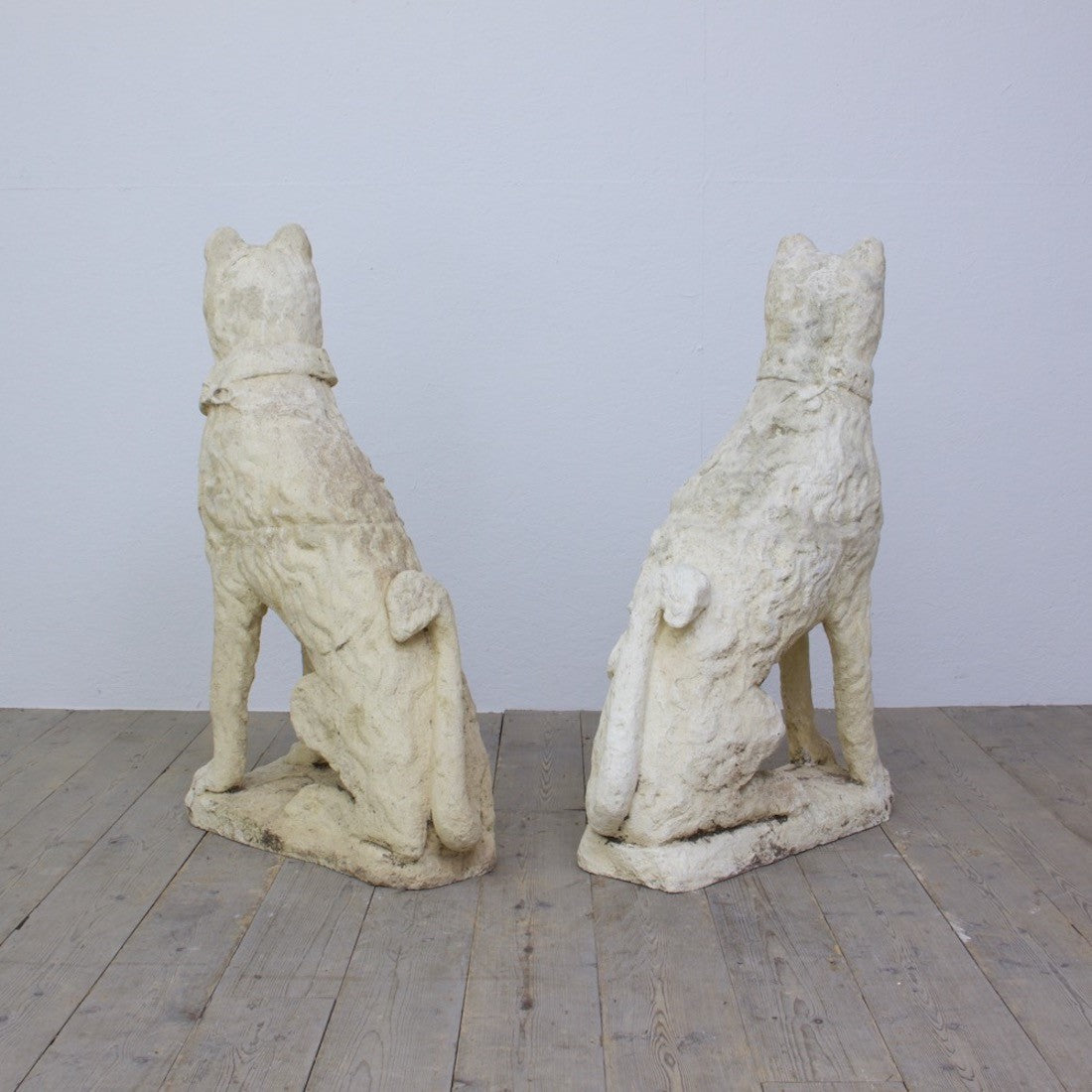 A pair of cast stone dogs