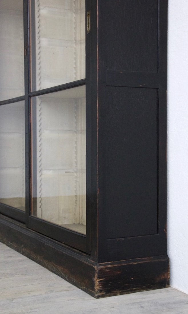 An ebonised sliding door cabinet